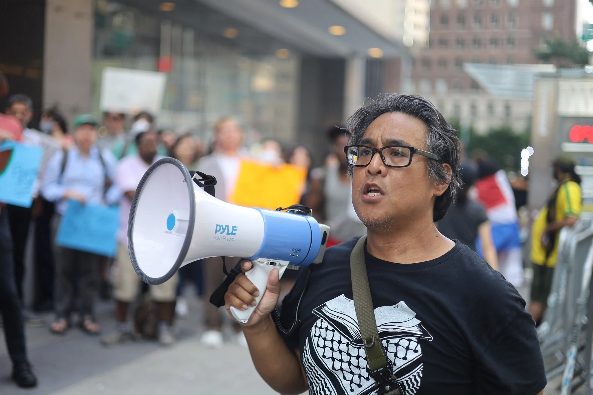 Labor movement organizer stands with a megaphone to lead the crowd