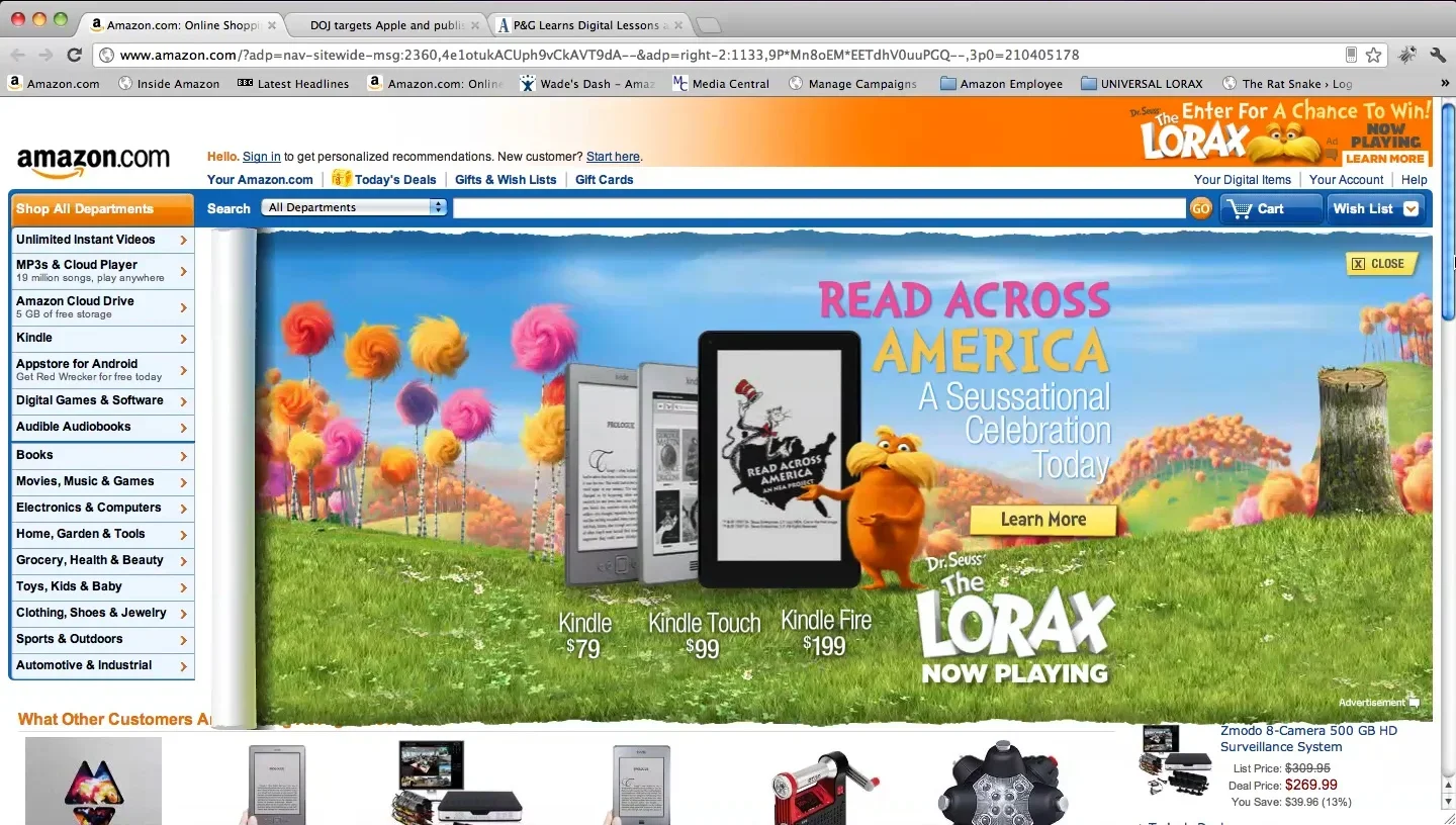 Amazon.com homepage featuring an advertisement for "Read Across America" digital books, with images of Kindle devices, colorful trees, and Dr. Seuss character the Lorax.