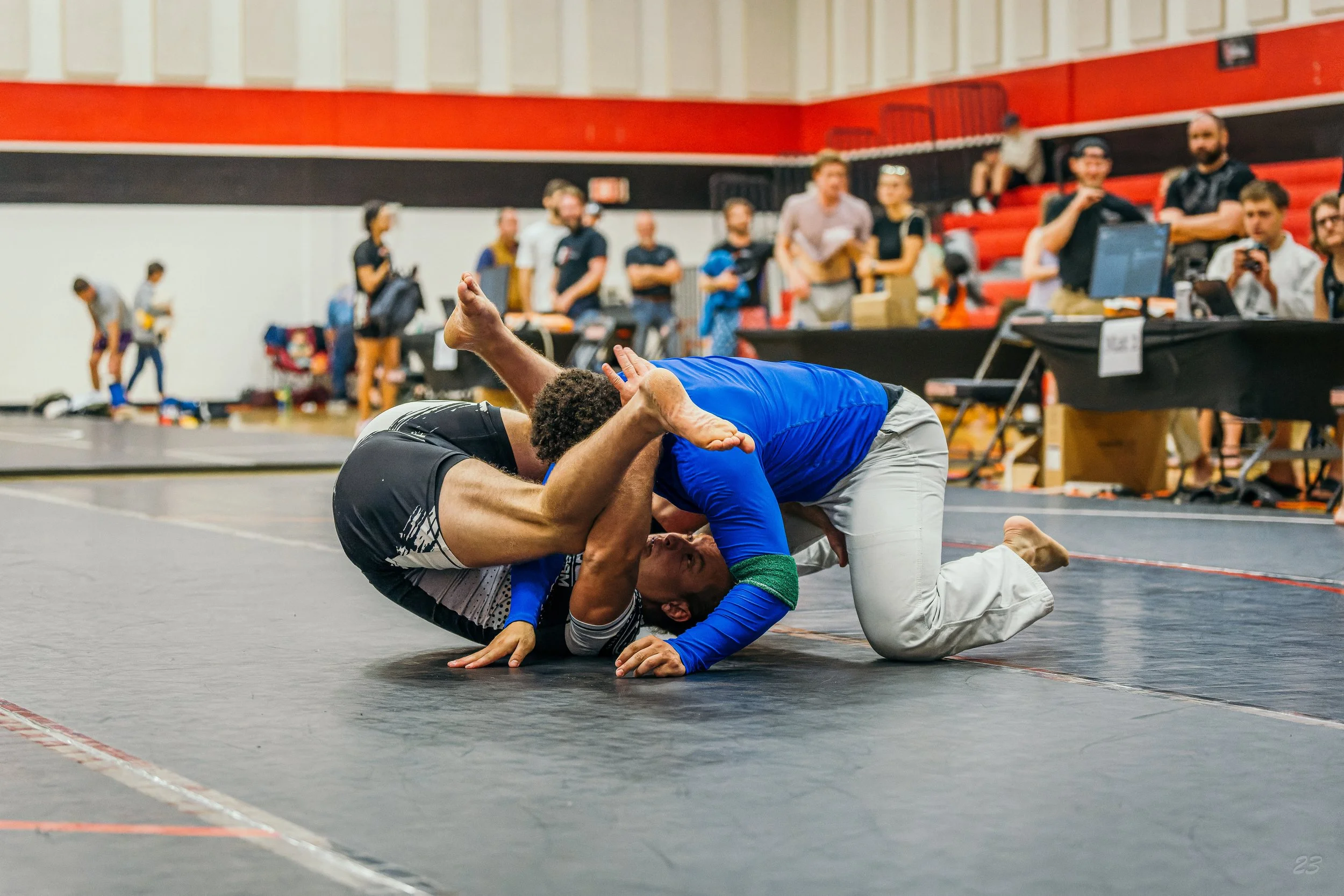Two adult Brazilian jiu-jitsu competitors grapple from guard during a no-gi match at the South Dakota Open.