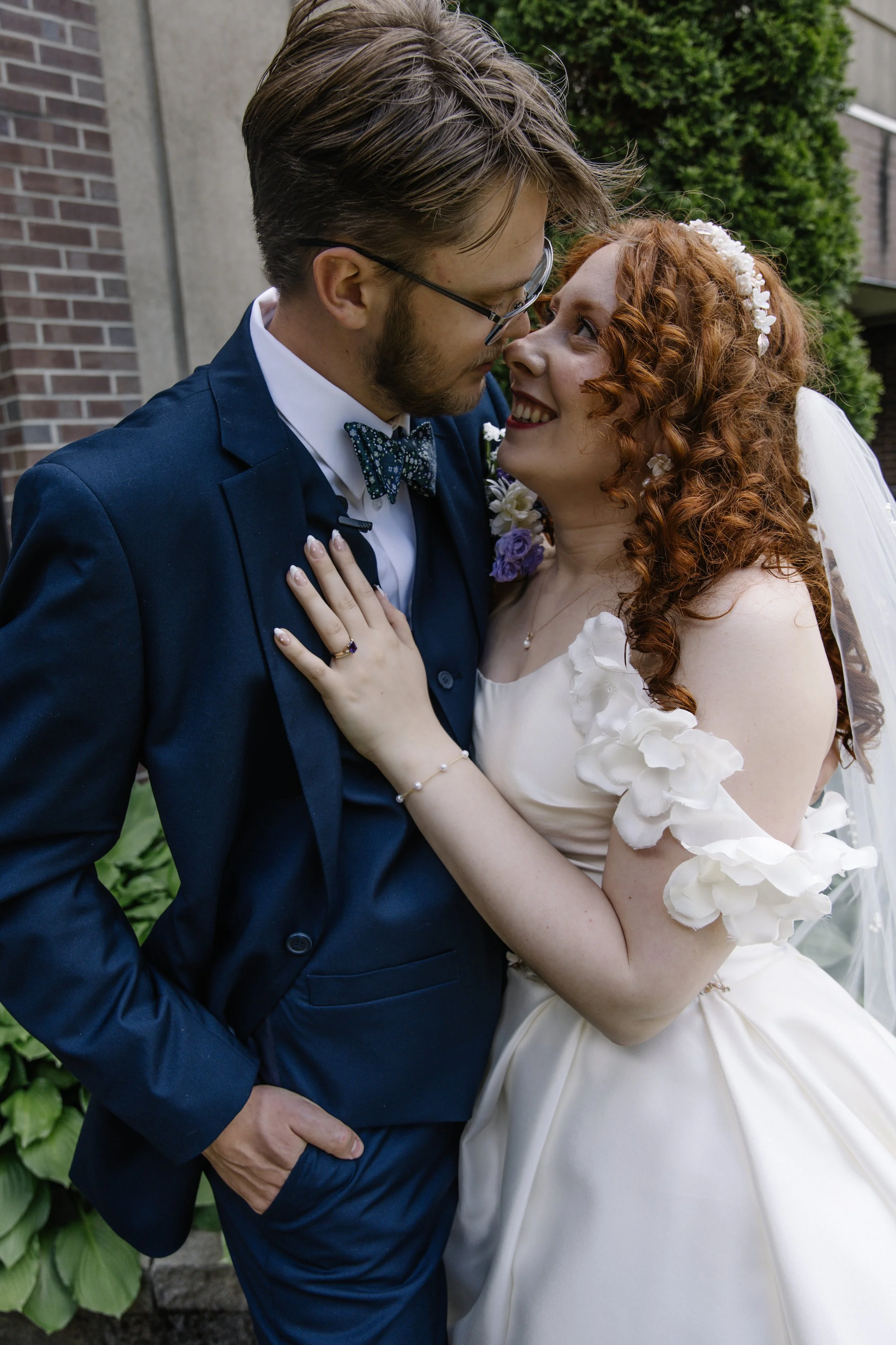 A bride and groom standing close, looking into each other's eyes during their wedding.