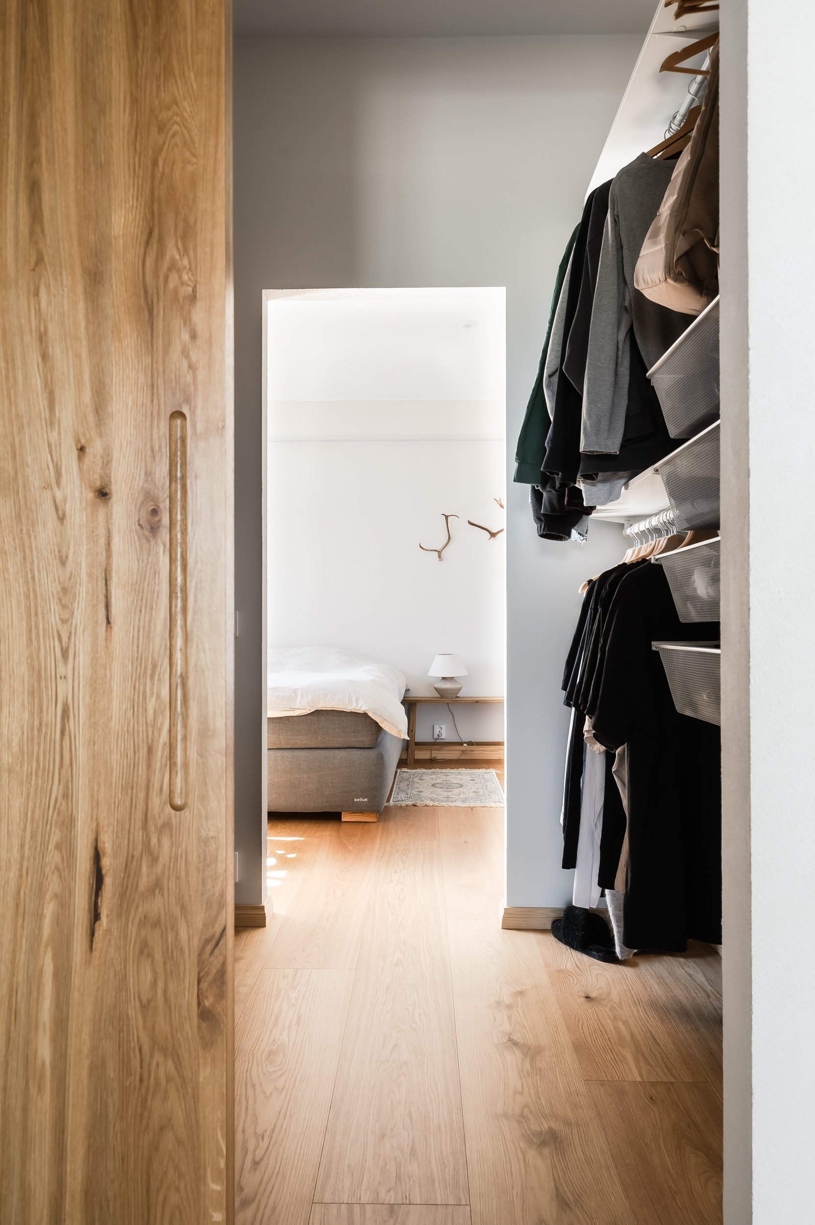 Kuva walk in- vaatehuoneesta. Vaatehuoneen ovi on puusepän tekemä kaunis ja iso liukuovi. 
