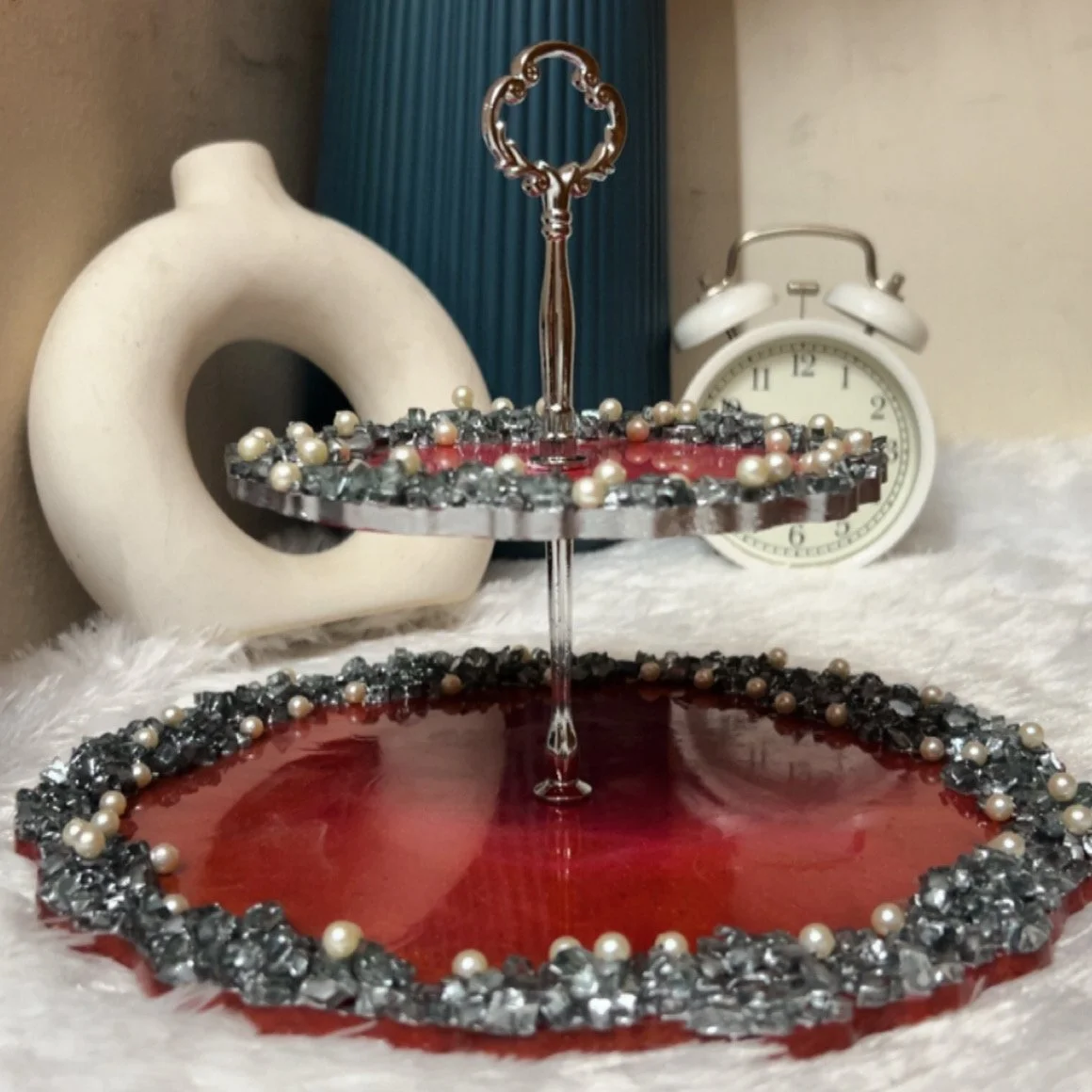 Make every celebration unforgettable with our handcrafted 2-tier resin cake stand, designed to bring a luxurious touch to your dessert table/ Dressing Vanity. Featuring a rich deep-red resin finish, sparkling crystal-like accents and delicate pearl d