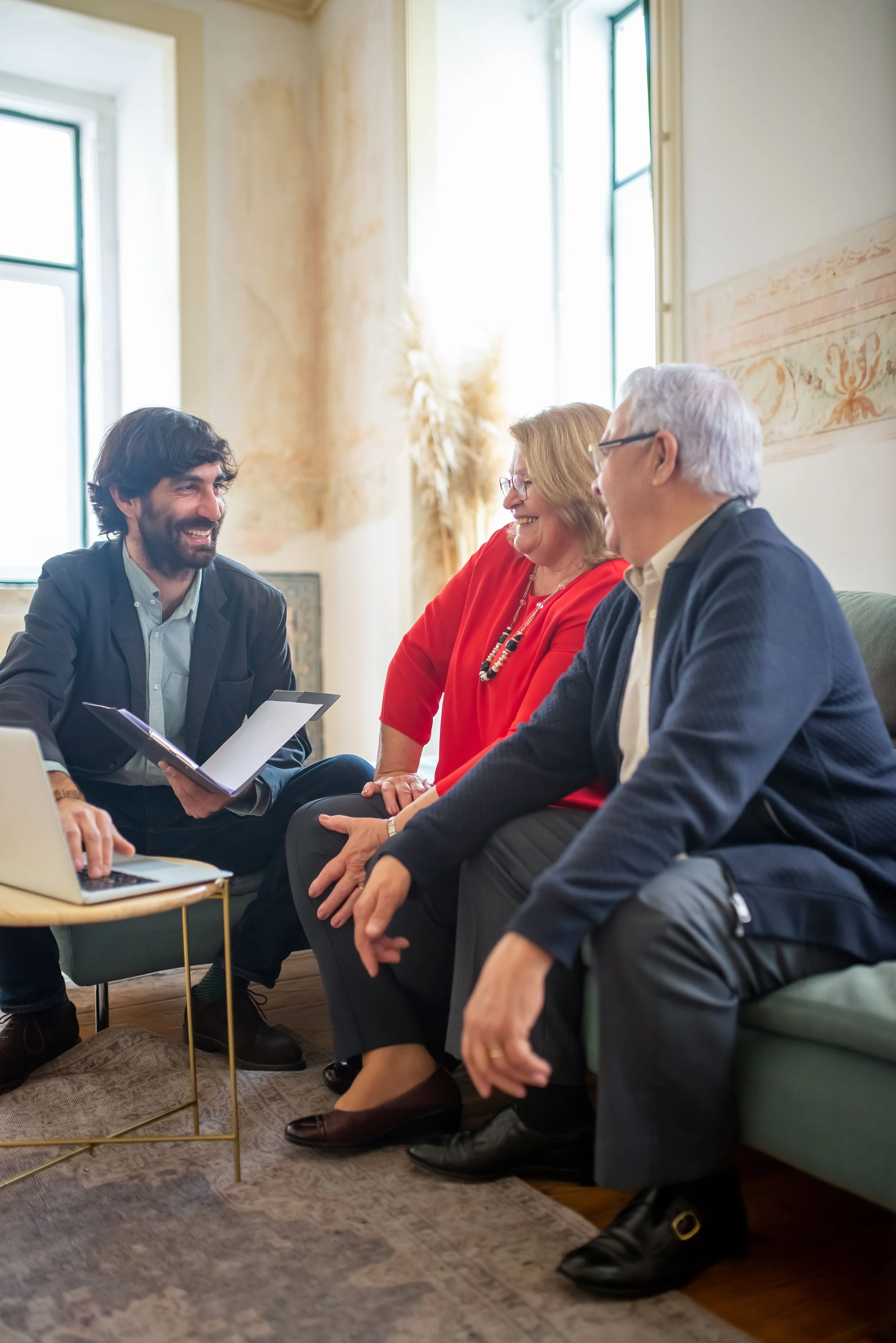 A senior living advisor meeting with an older couple in a bright, comfortable room, reviewing options together.