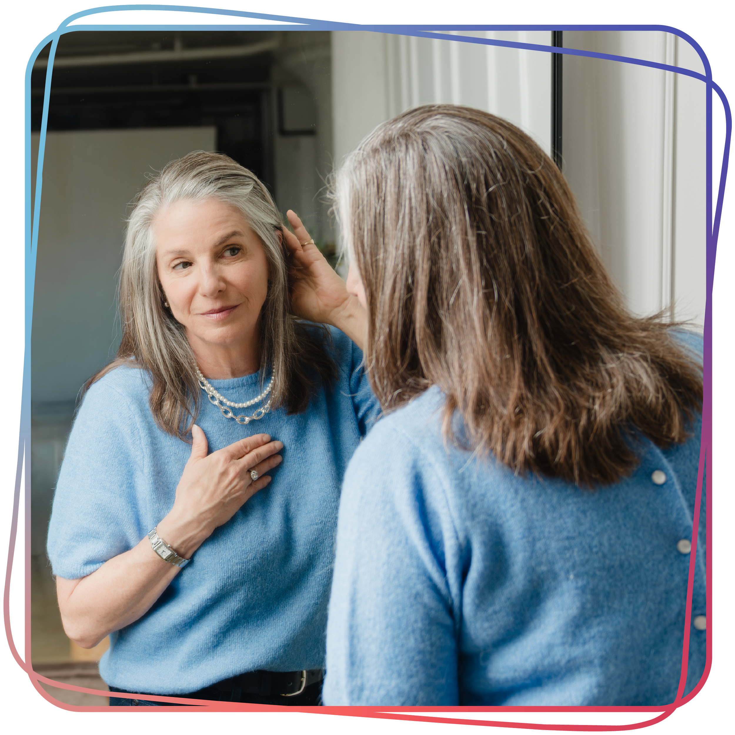 Wendy Shami touching her hair, looking at herself in a mirror.