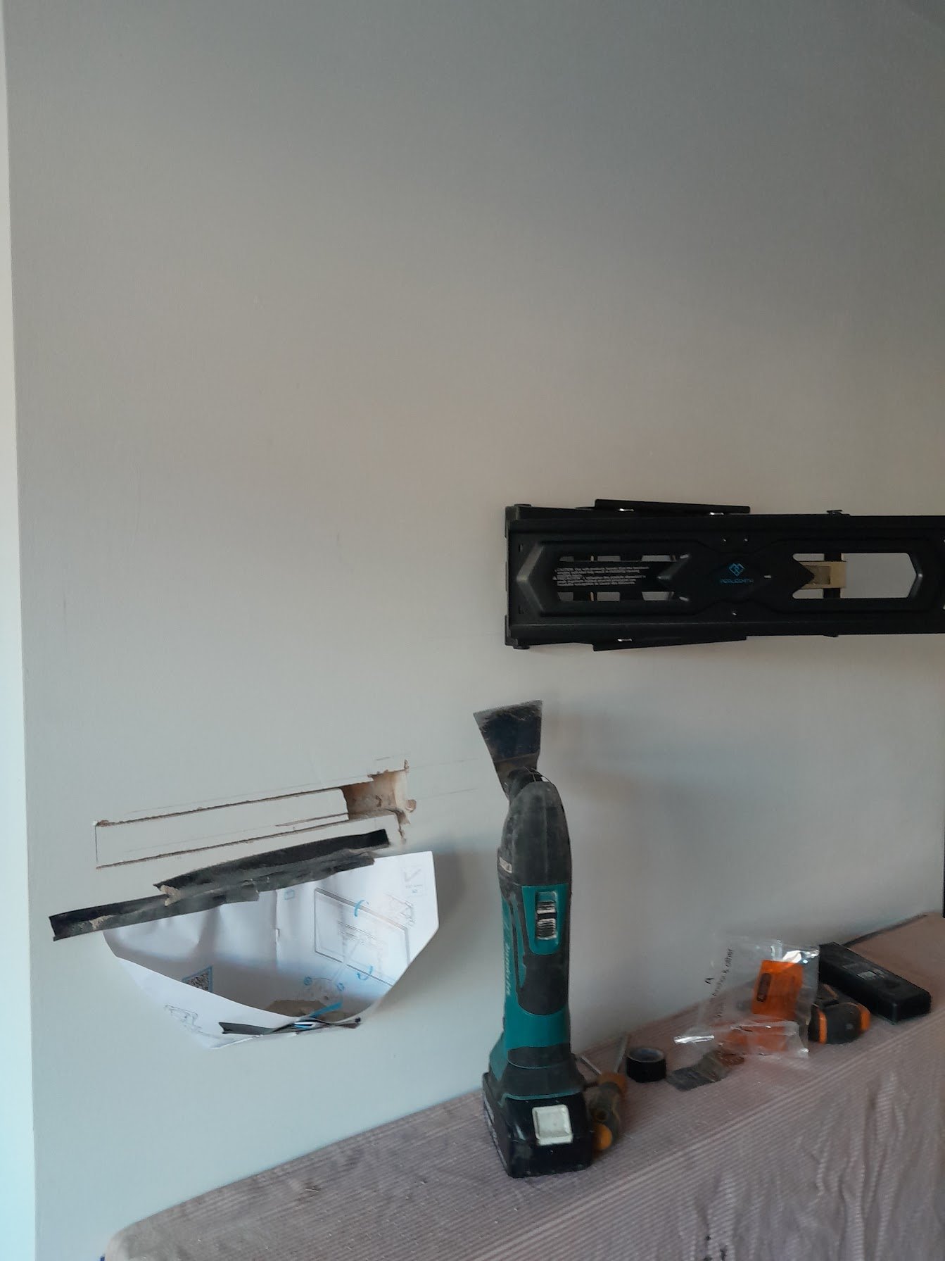 Plasterwork being chopped out on a chimney breast for cable installation to wall mounted tv