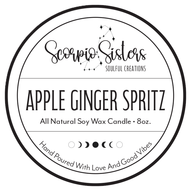 A round label for Scorpio Sisters All Natural Soy Wax Candle with an apple ginger scent, including celestial moon phases and star designs, and the tagline 'Hand Poured With Love And Good Vibes'.