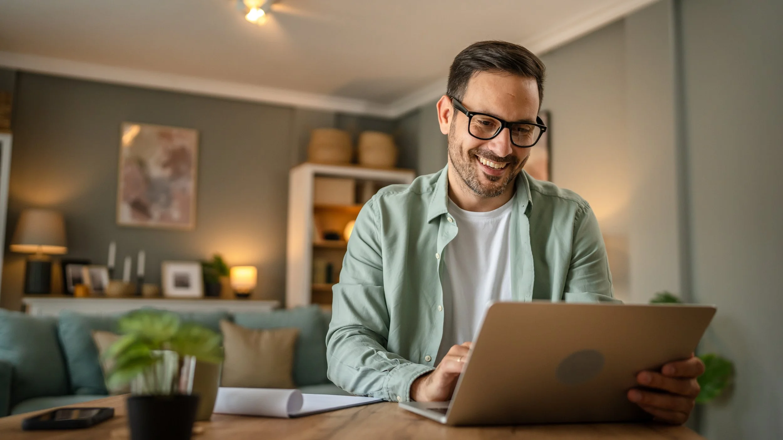 Smiling man using a laptop at home to explore healthcare membership plans with Reclaim Direct Primary Care in Burleson.