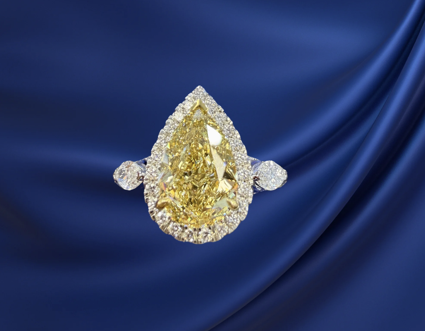 Pear‑shaped yellow lab‑grown diamond ring on blue satin background at SINO Fine Jewelry in Boca Raton.