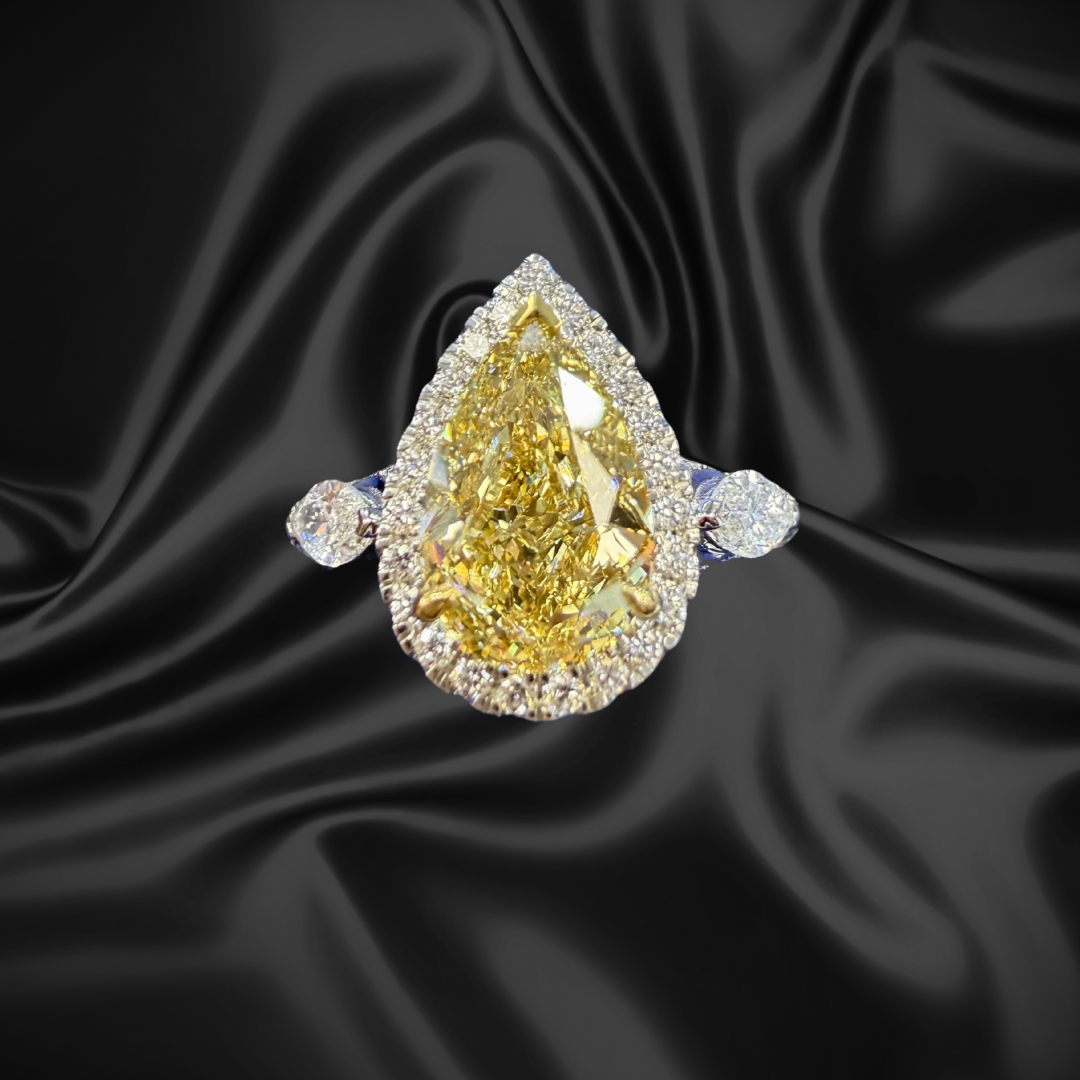Pear‑shaped yellow lab‑grown diamond ring on blue satin background at SINO Fine Jewelry in Boca Raton.