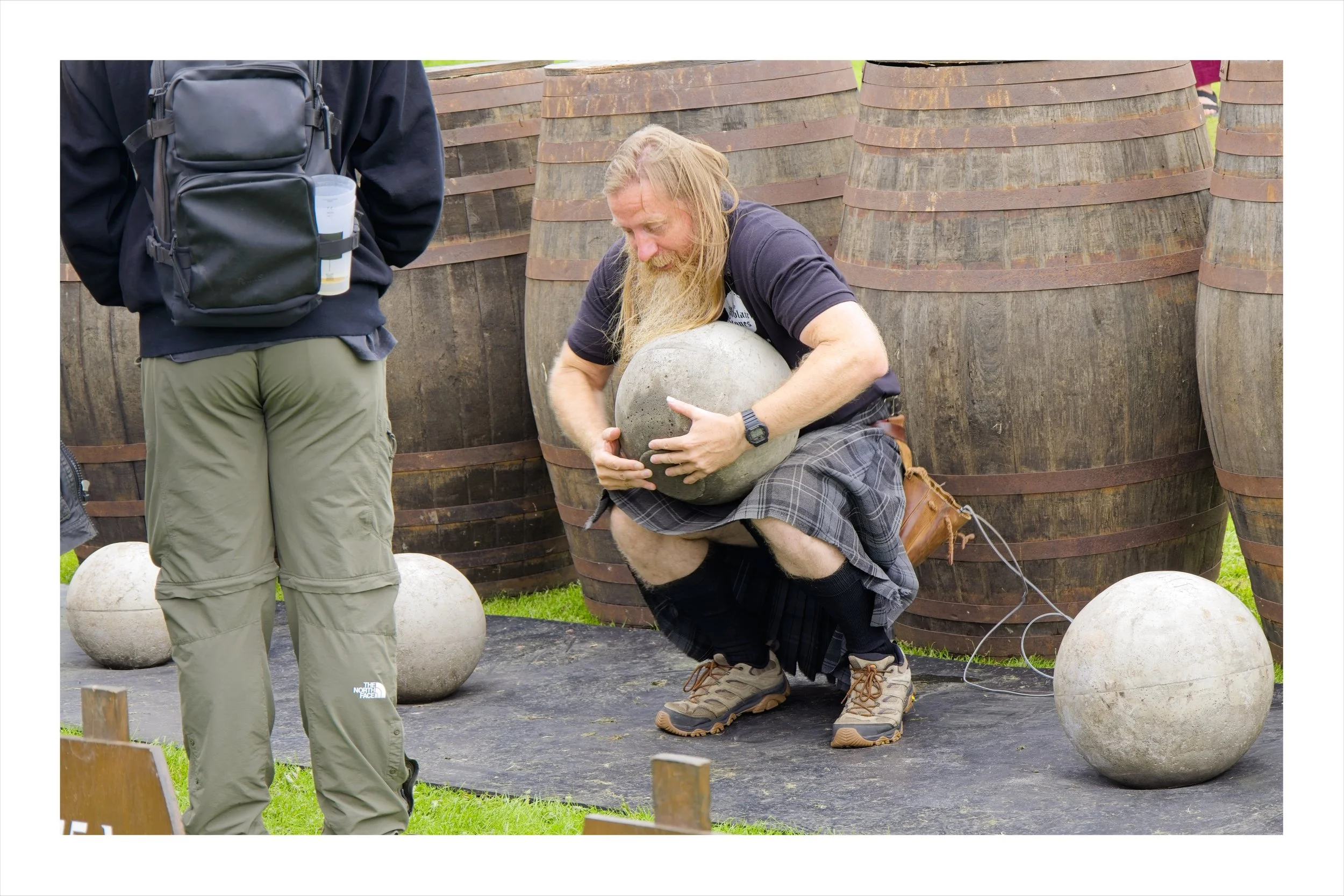 A man trying to lift a heavy stone at a highland games in Perth, Scotland