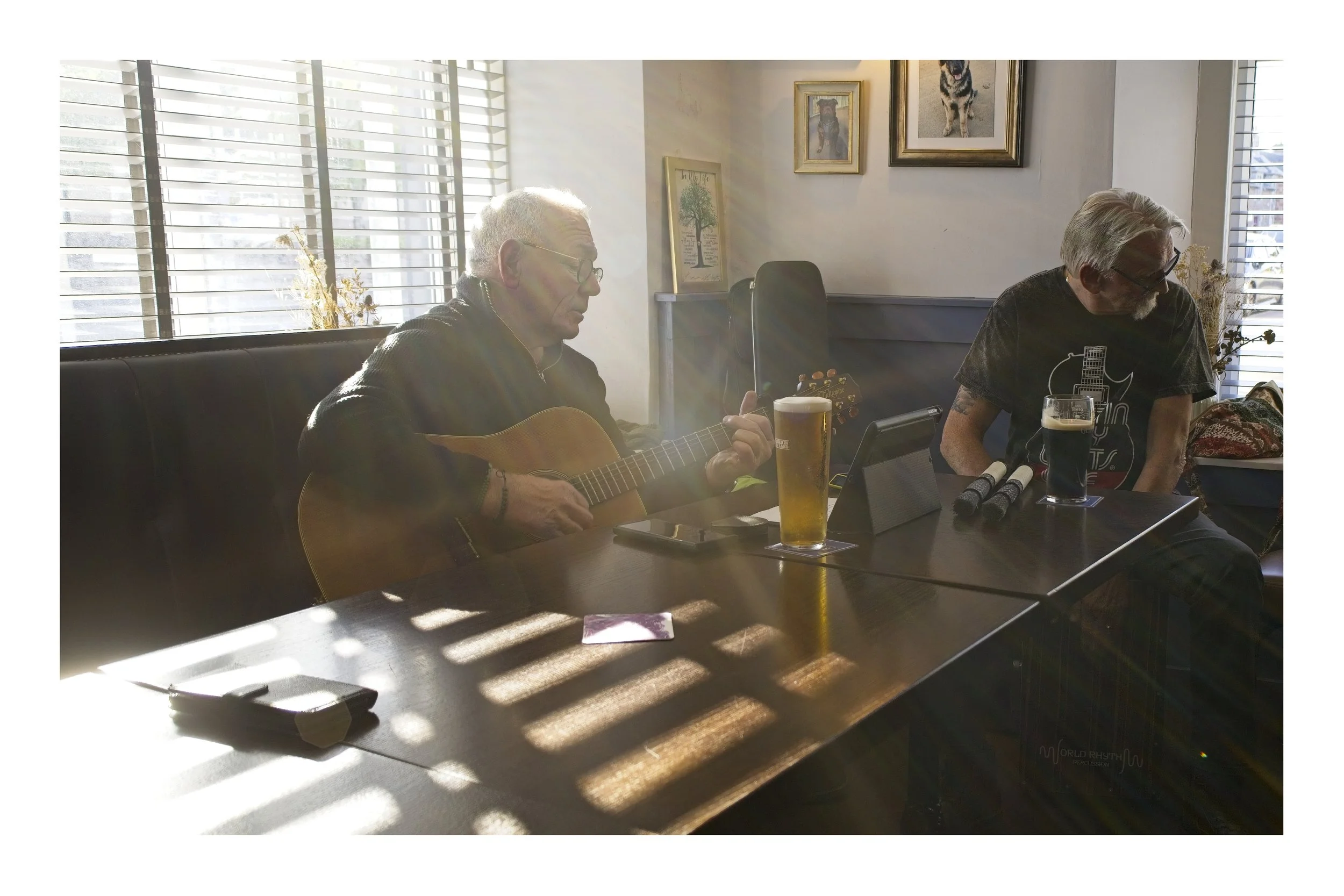 A man singing in a pub as sunlight streams through the window