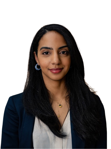 Professional woman with long black hair, wearing a navy blazer, white blouse, and jewelry, smiling against a dark background.