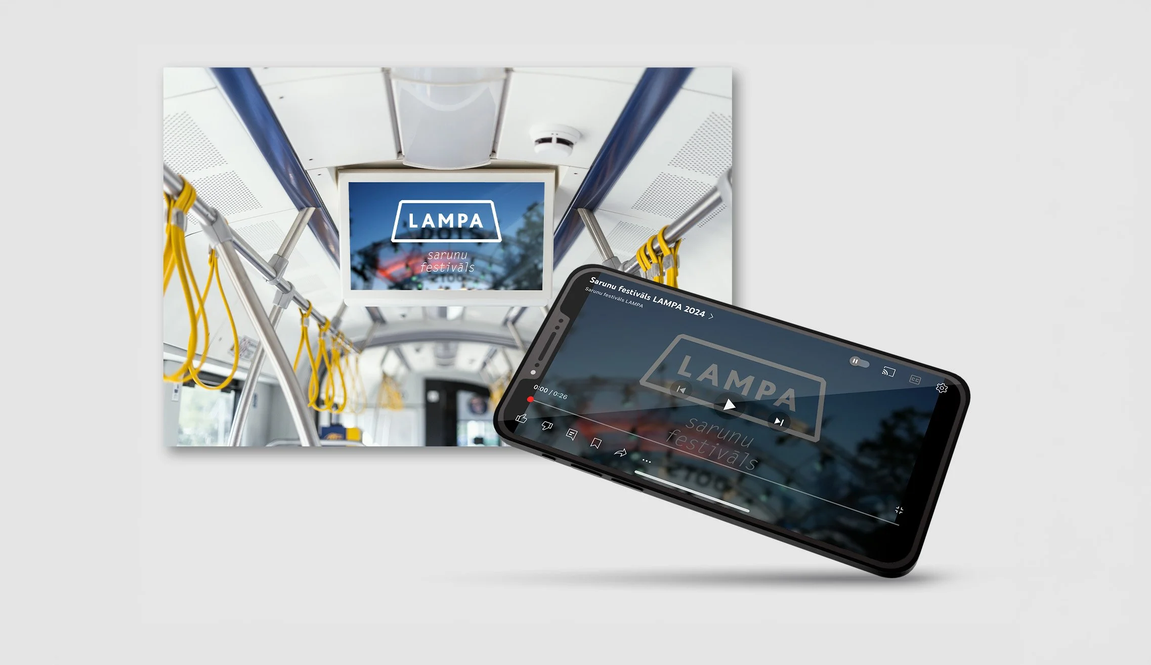 A smartphone showing a paused video with the text 'LAMP A Sarunu festivāls' on a bus interior screen, with yellow hand straps and a view of the sky and trees reflected in the screen.