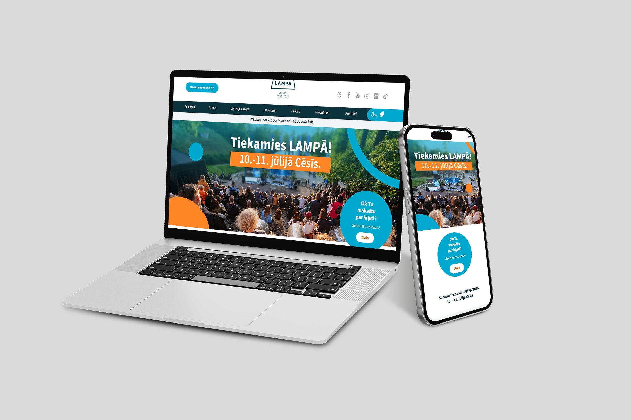 A laptop and a smartphone displaying a website about the LAMPA festival, mentioning dates July 10-11, with an image of an outdoor concert audience.