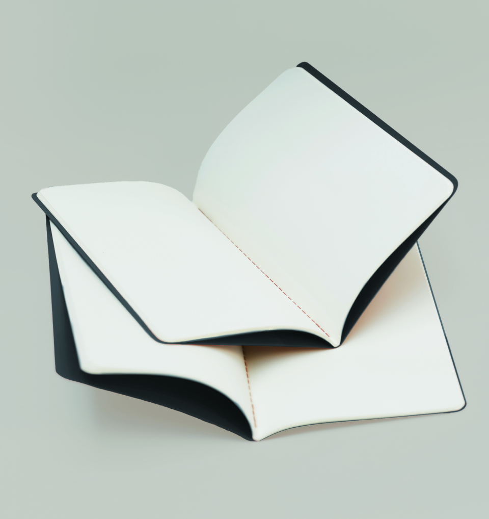 Two black and white hardcover books with blank pages, one placed on top of the other, on a light-colored surface.