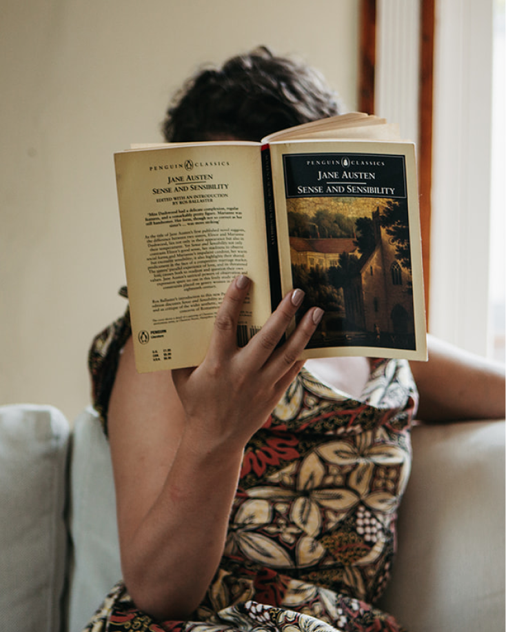 Person reading Jane Austen's "Sense and Sensibility" in a cozy setting.