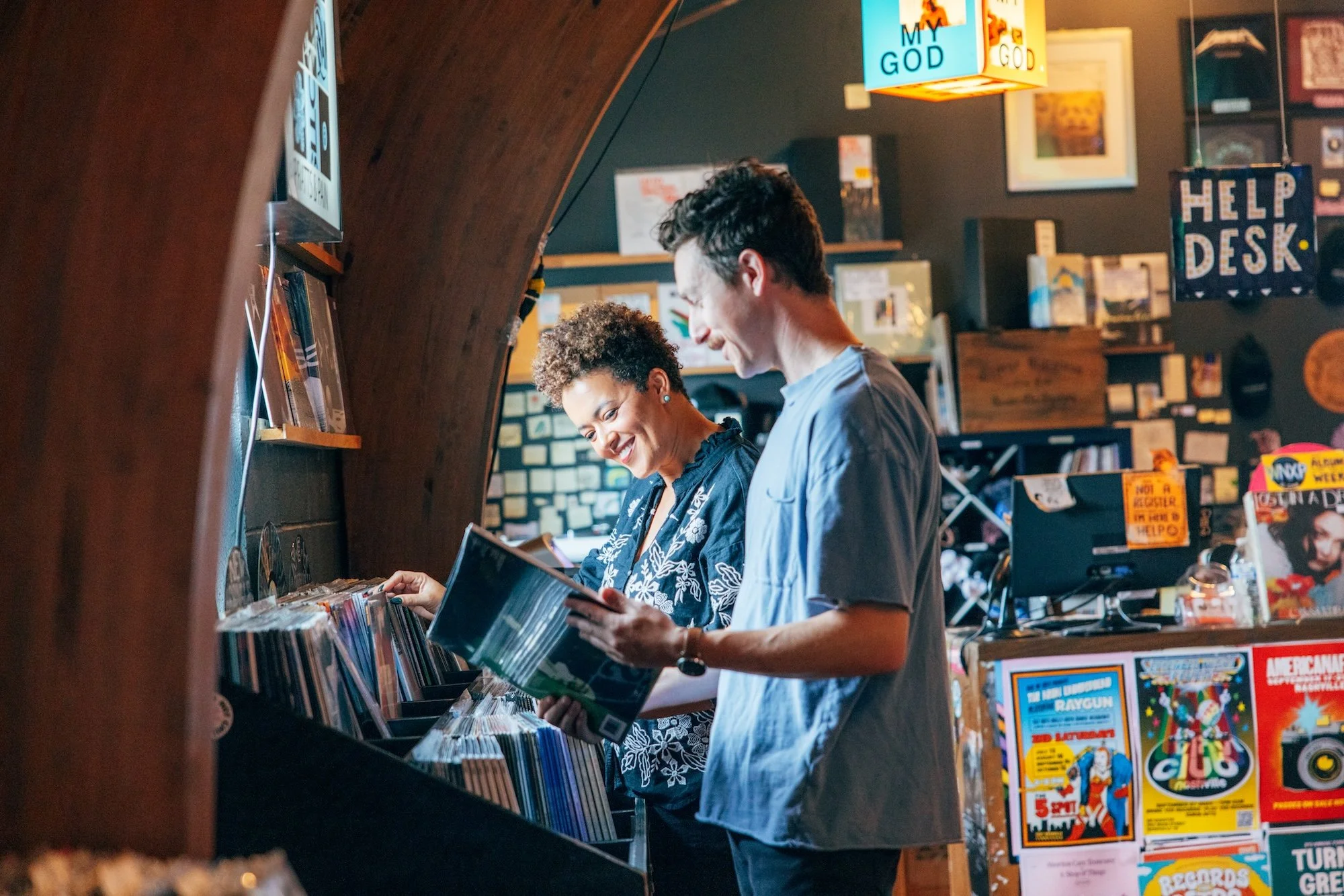 Two people shopping for records inside Grimey's, a record store in East Nashville, browsing through vinyl albums.