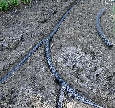 Underground cables laid in a trench with protective tubing.
