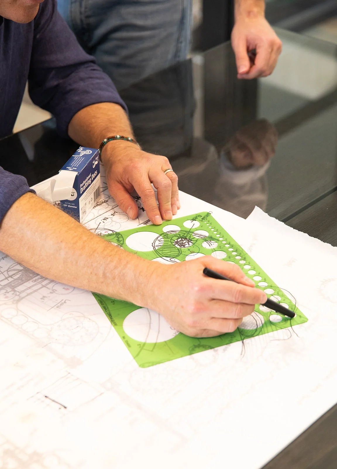 Designer drafting a planting plan with a circle template