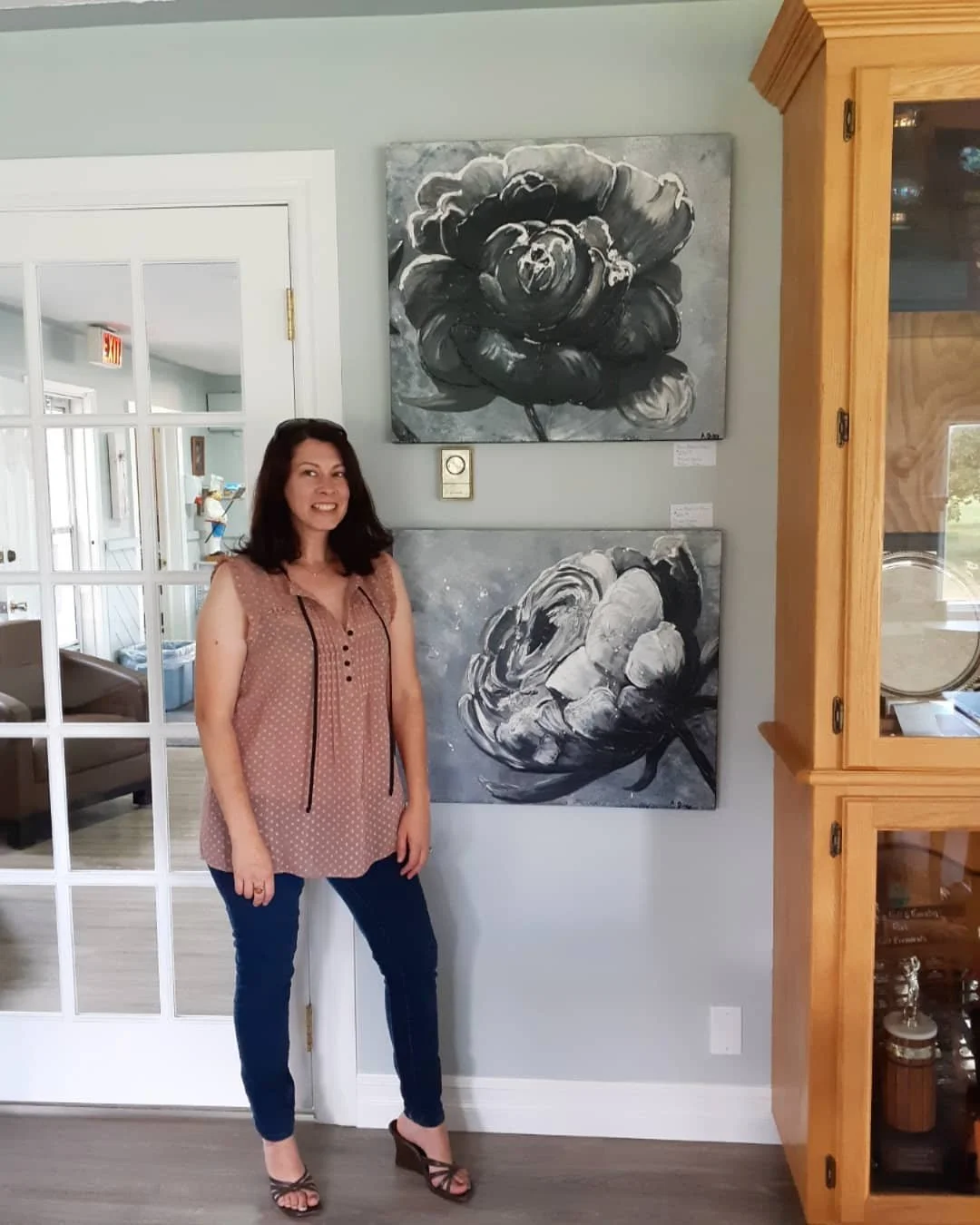 Amber standing next to two black and white paintings