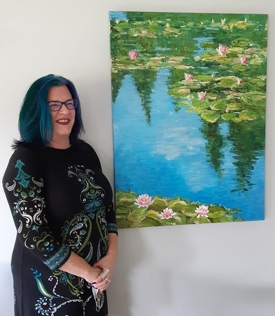 Jane standing next to a large oil painting of lilypads