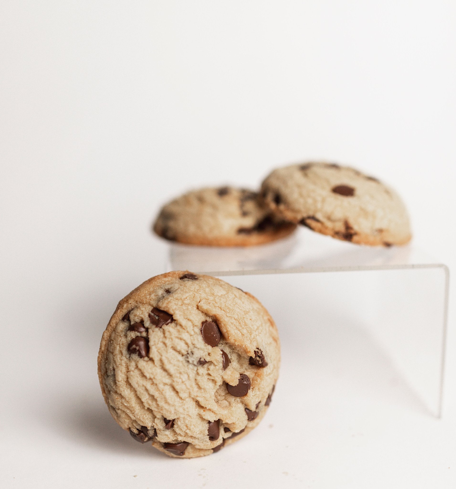 Close-up of a chocolate chip cookie on a white surface.
