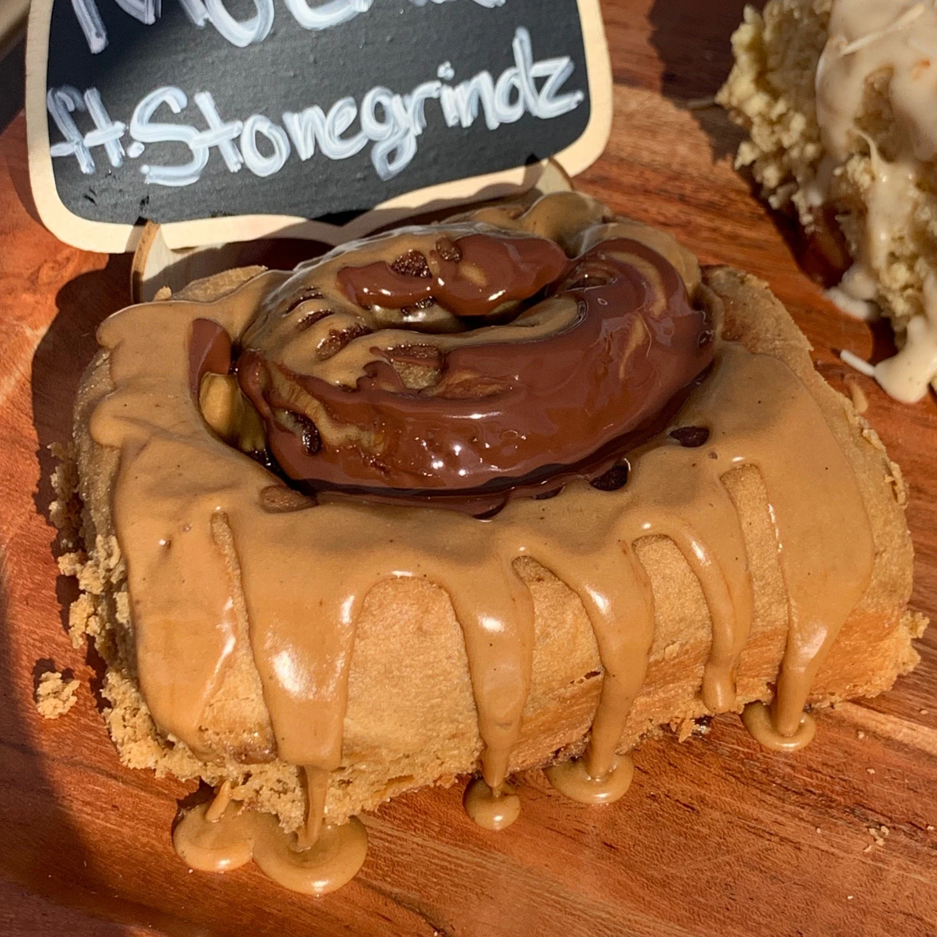 A Scroll topped with peanut butter, caramel sauce, chocolate chips, and a caramel-covered pretzel. 