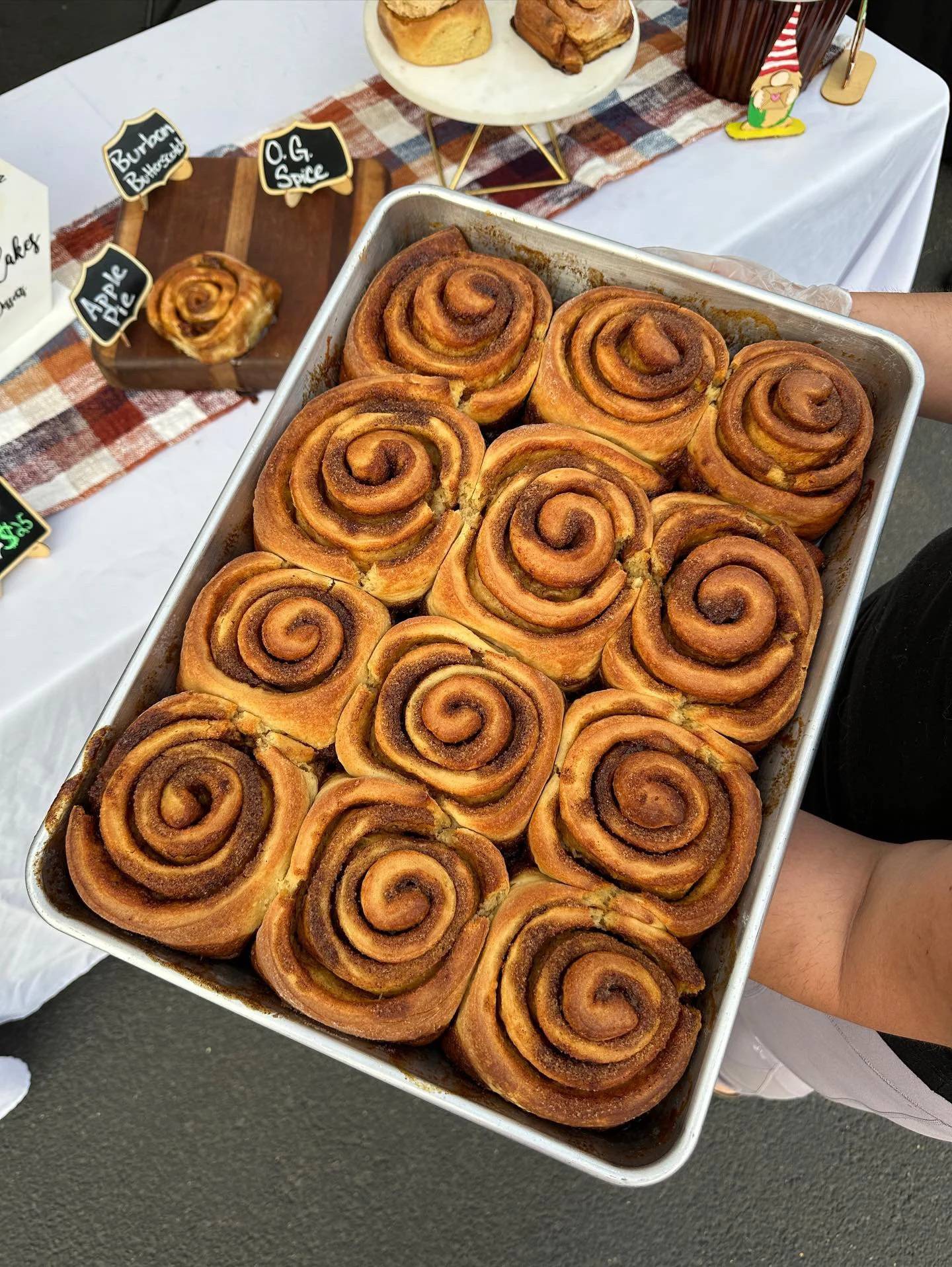 A tray of cinnamon rolls with a golden-brown crust and swirled cinnamon filling.