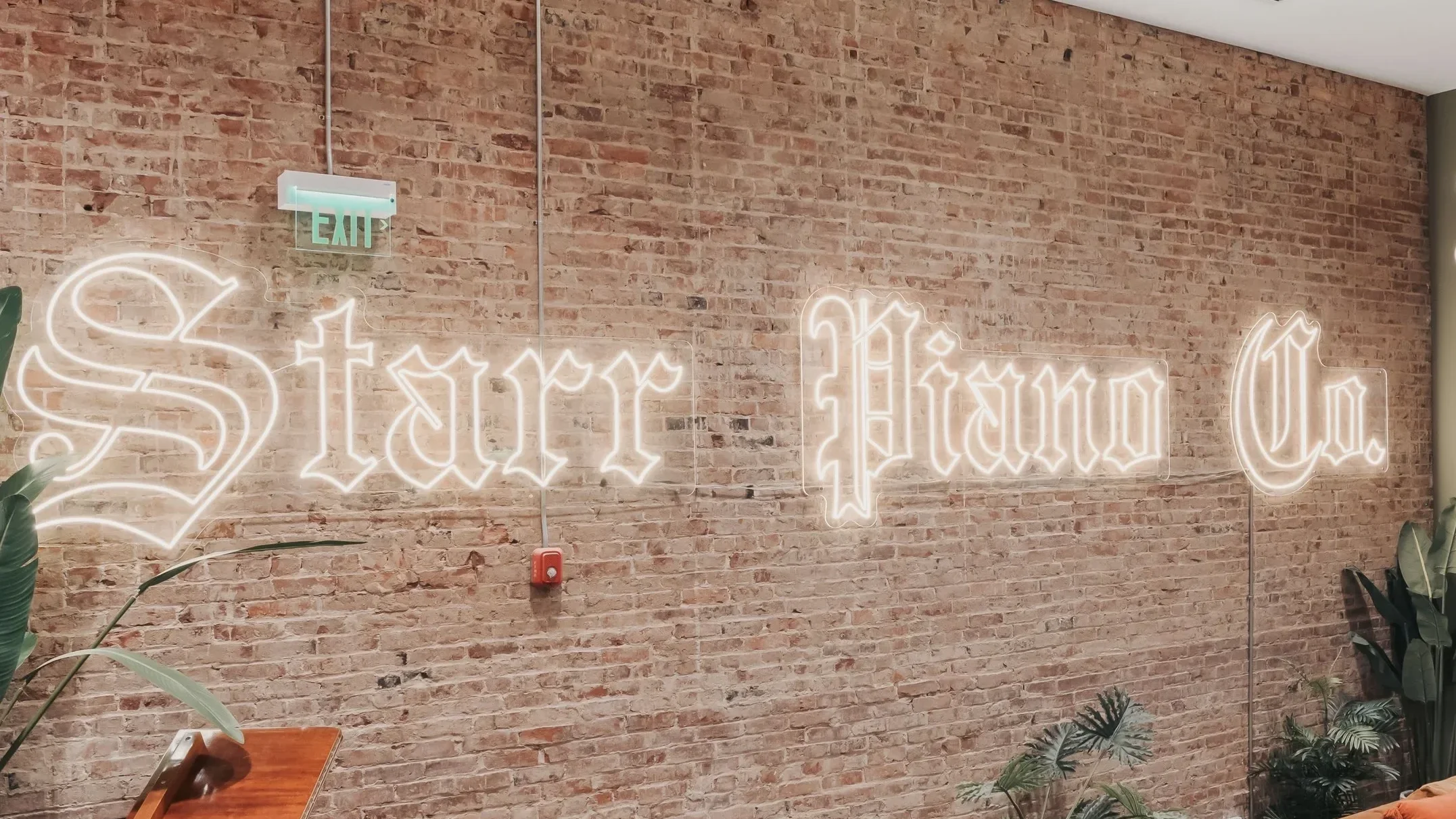Neon sign on brick wall that reads 'Street Hard'.