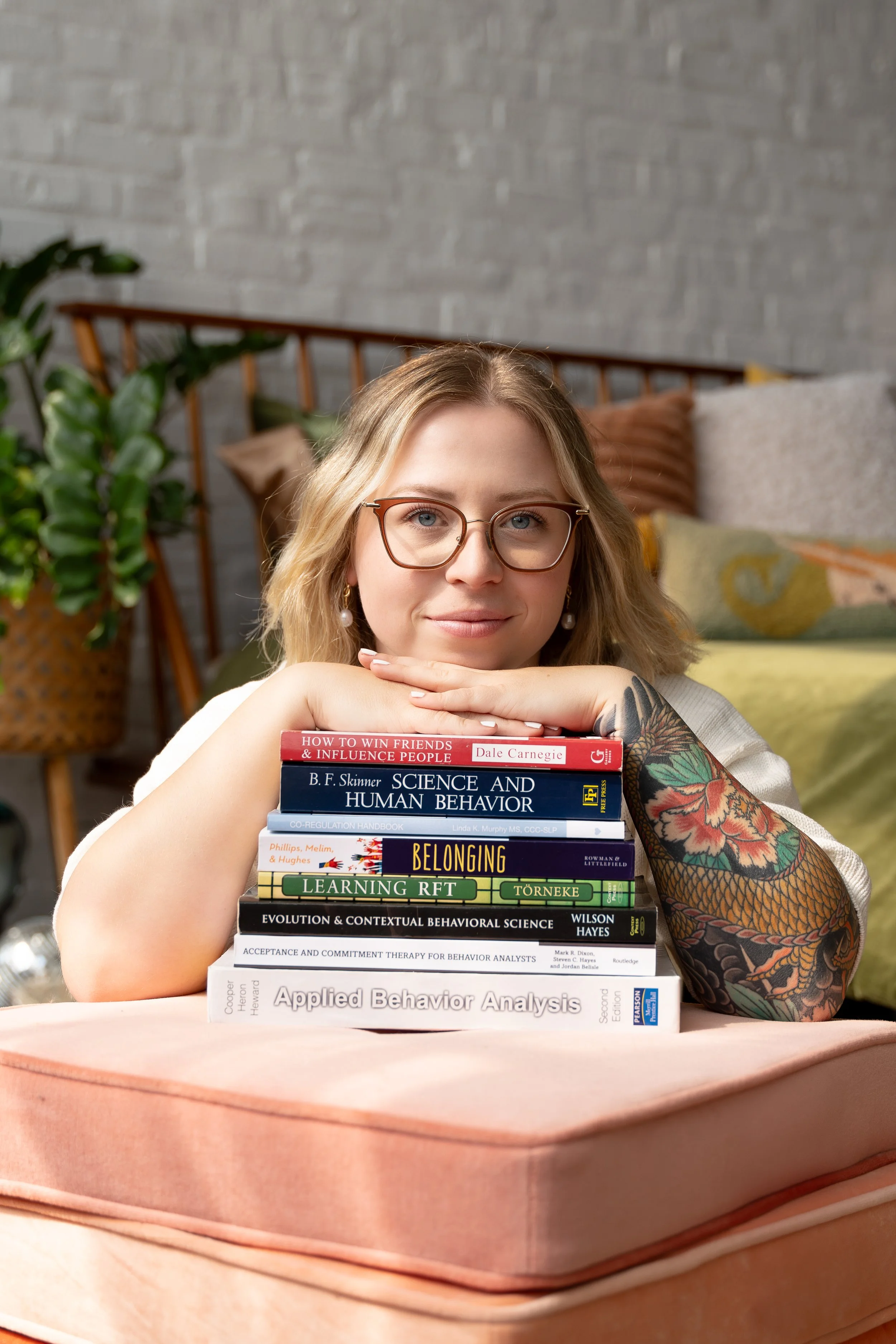 Kelsey Hunter, BCBA supervisor with a stack of applied behavior analysis and ACT reference books