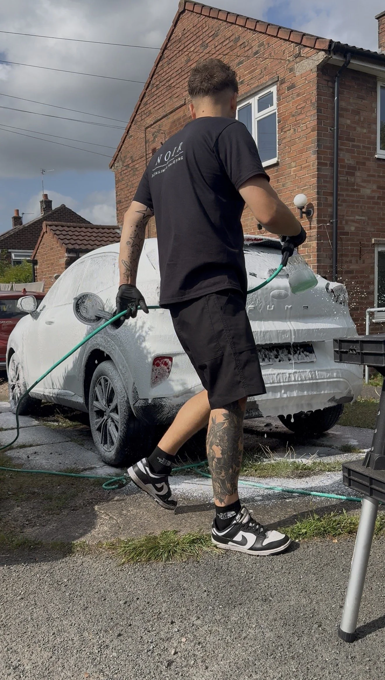 Luke from Noir Detailing Knutsford snow foaming a car during a mobile valet