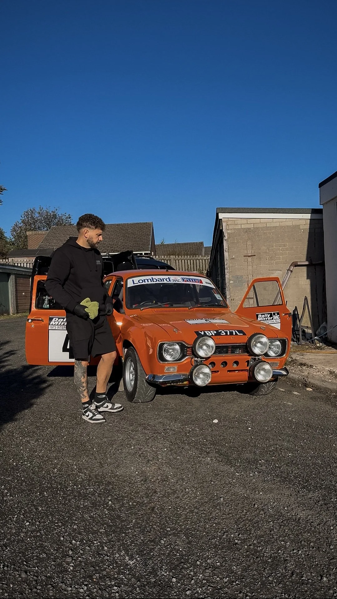 Luke from Noir Valeting and Detailing standing beside a classic rally car