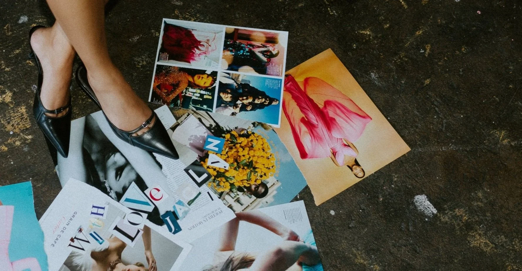 Scattered fashion magazines and photographs on a dark floor with Jaclyn wearing black pointed-toe high heels.