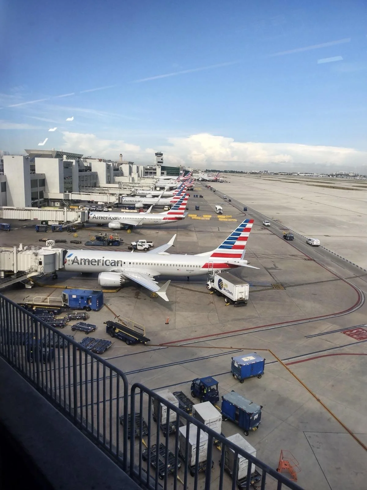 Multiple American Airlines airplanes parked at airport gates