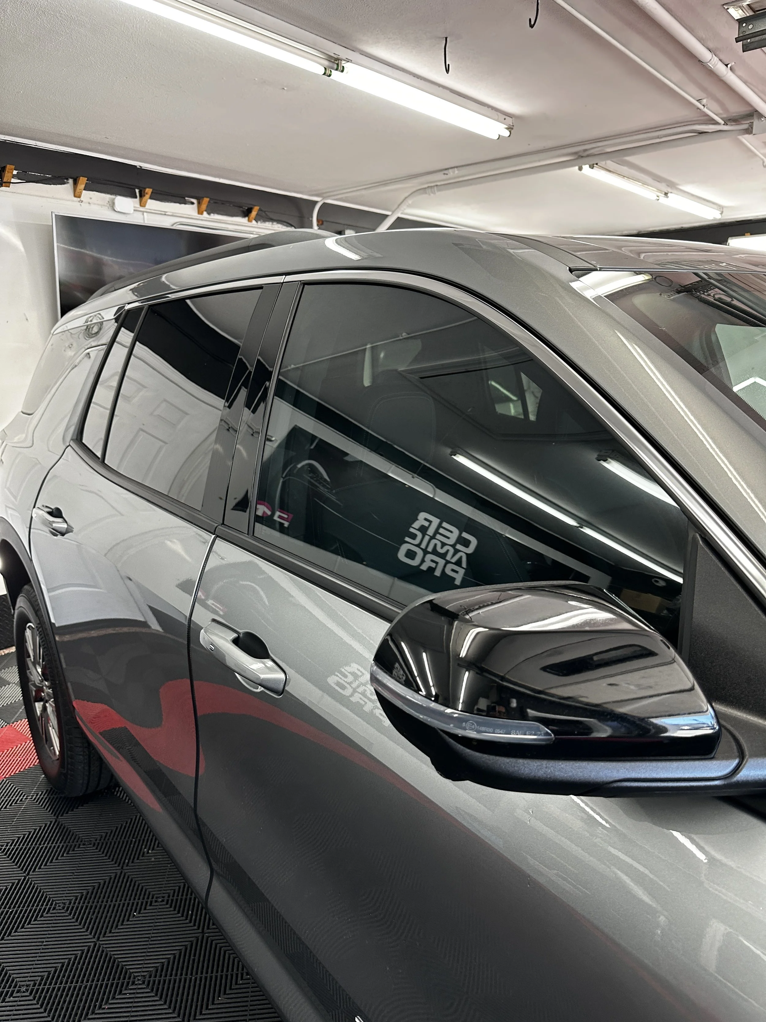Side of a silver SUV with window tint installed at Show Form Studio