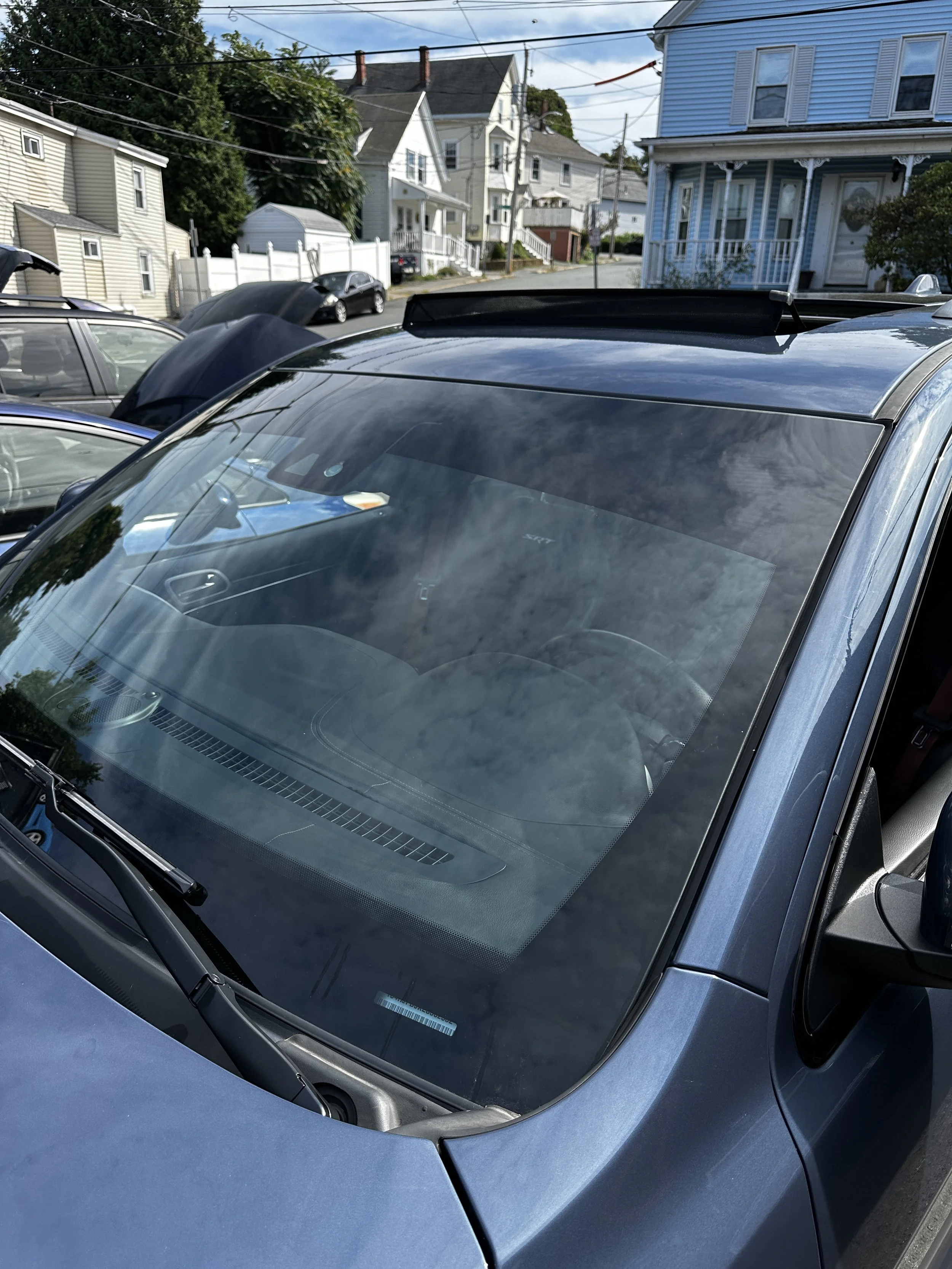 Freshly detailed windshield and hood with a glossy, water-beading finish