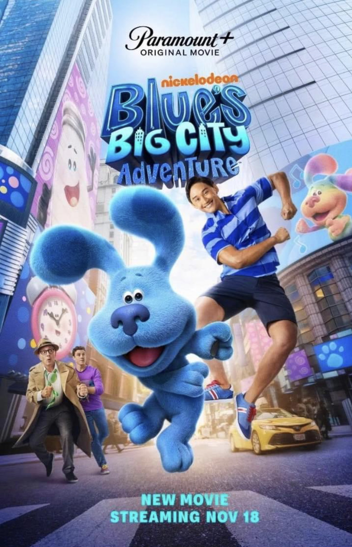 Poster for the animated movie 'Blue's Big City Adventure,' streaming starting November 18. Features Blue, a blue cartoon dog, running through a city street with excited children and colorful billboards in the background.