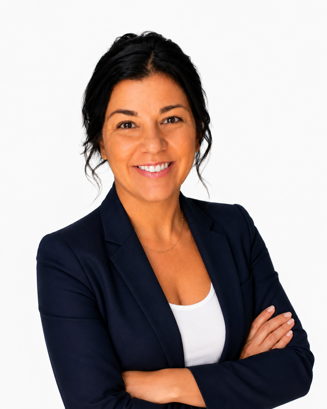 Professional woman smiling with arms crossed, wearing a navy blazer and white top, against a white background.