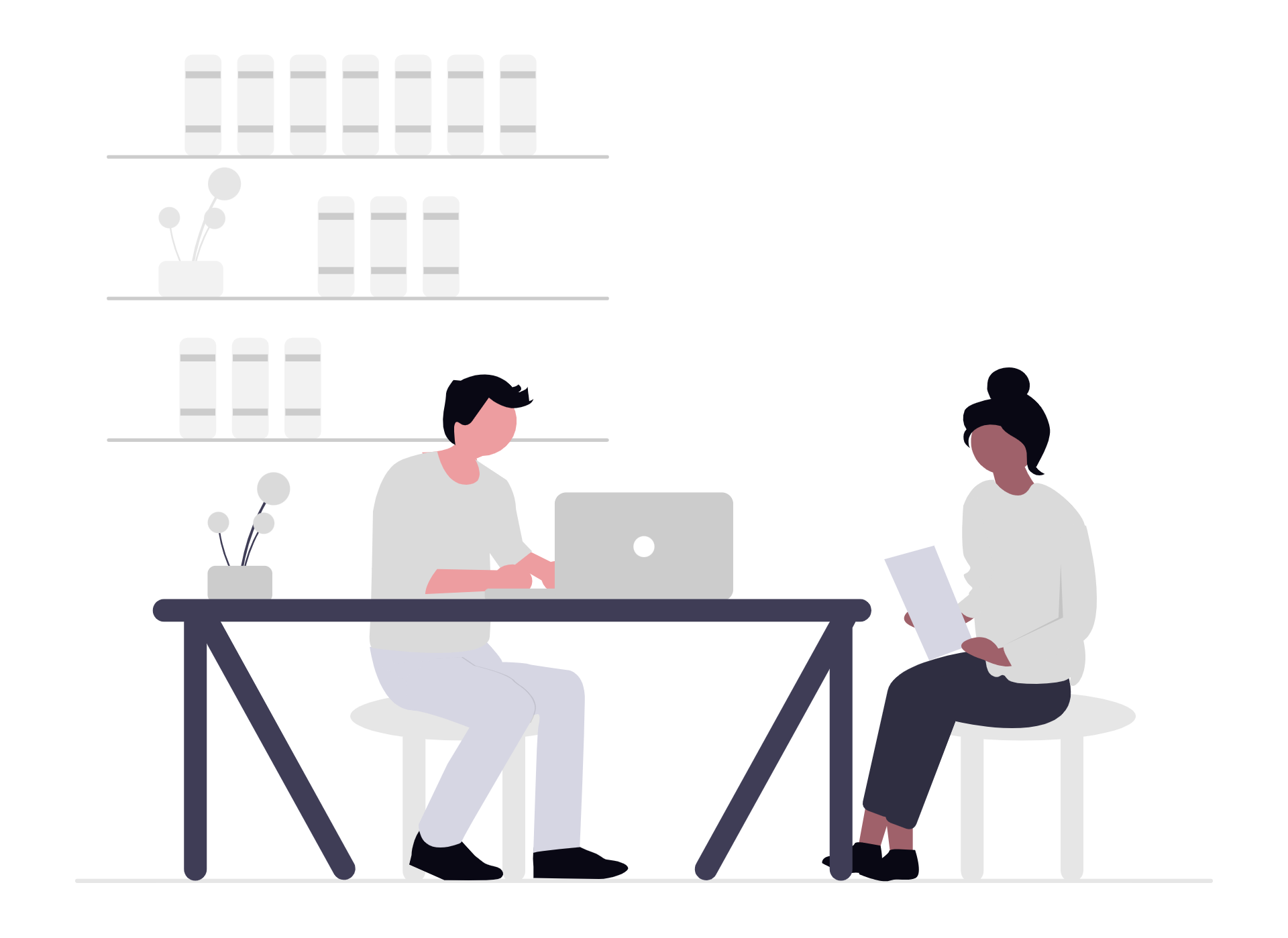 Two women are working together at a large table, one is sitting and using a laptop, the other is kneeling and holding a tablet. The setting appears to be a modern office or workspace with shelves of binders and plants in the background.