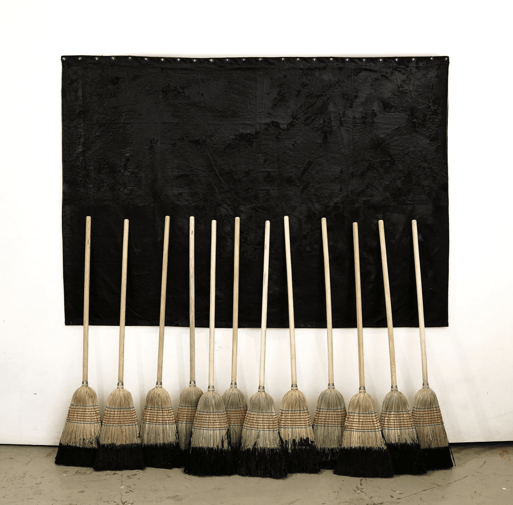 Broom Reliquary l, 2021
Tarred Tarp and Tarred Brooms
(Relevant Debris buried under tarp)  
Dimensions Variable

Relicario de Escobas l, 2021  
Lona Enchapopotada c/Escobas Enchapopotadas
(Detrito Relevante enterrado bajo el chapopote)
Dimensiones Va