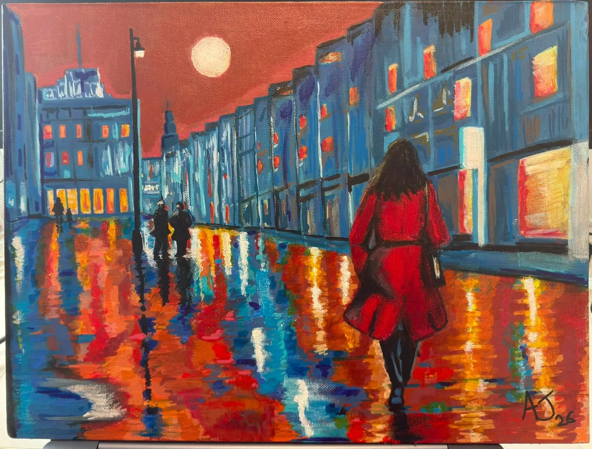 An impressionistic painting of a city street scene at sunset with a large moon in the sky. A woman in a red coat walks along the street, and three people are seen walking together near streetlights. Reflections of the buildings and lights shimmer on the wet pavement.