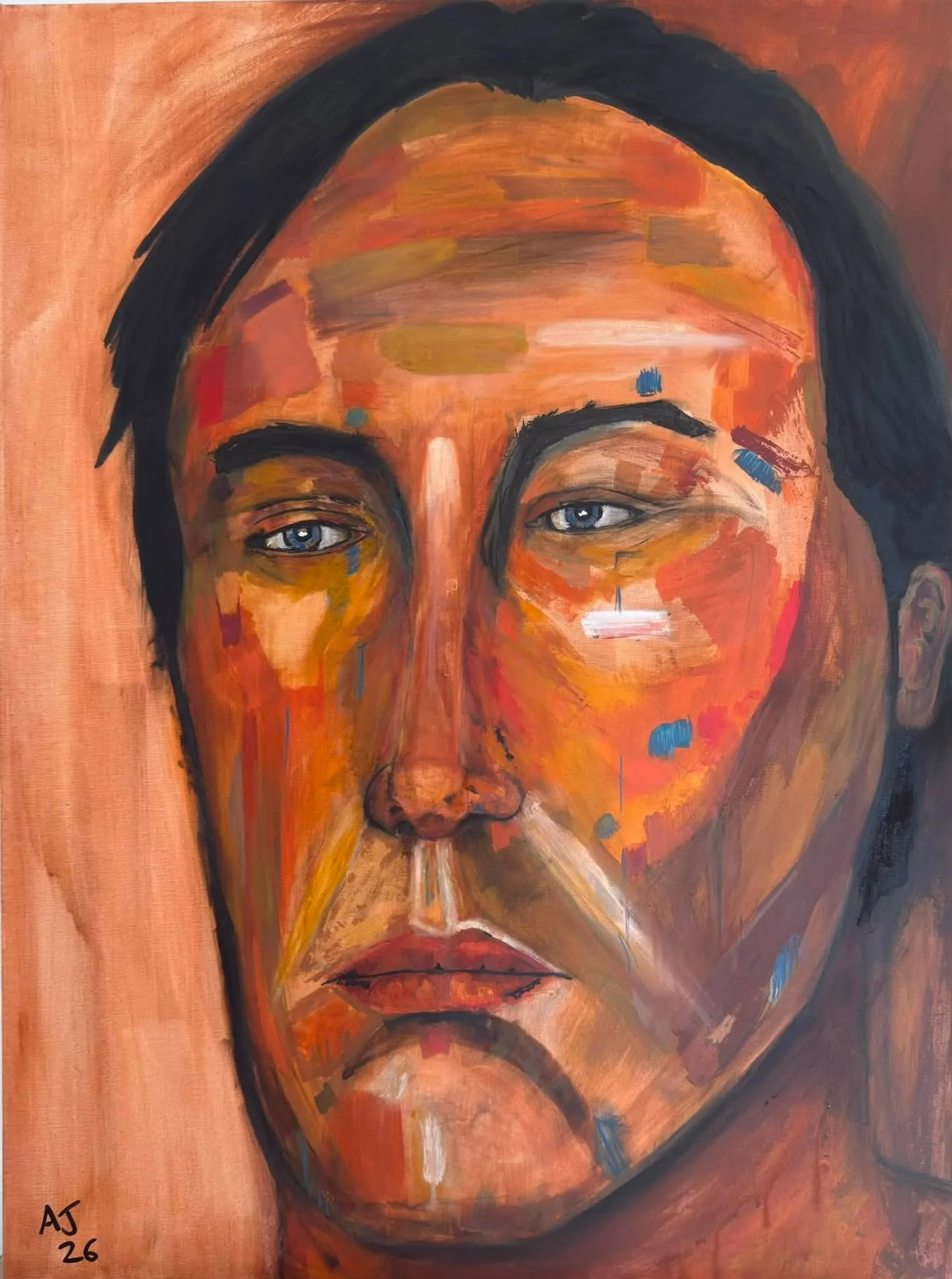 A portrait of a person's face painted with bold, expressive brushstrokes in warm tones. The person's eyes are blue, and they have dark hair. The painting is signed with initials 'AJ' and the date '26' in the bottom left corner.