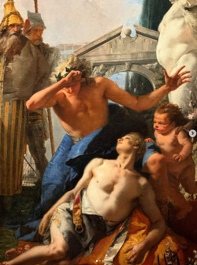 A classical painting depicting a dramatic scene with multiple figures, including a muscular man in blue with a wreath on his head, a woman lying on the ground, and children around them. Two men in historical attire observe from the background, set against an architectural backdrop.