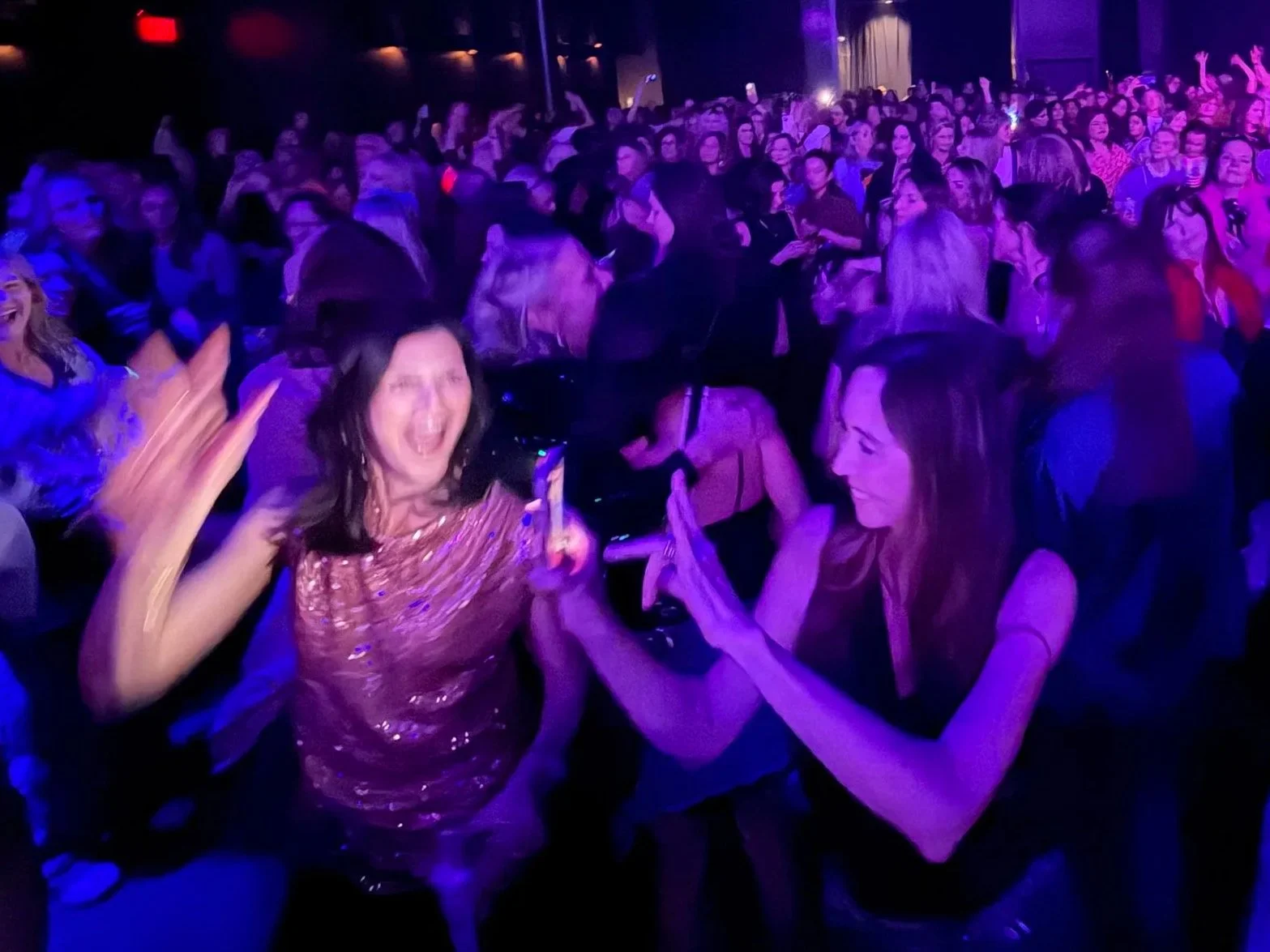 Adults dancing together at a live event.