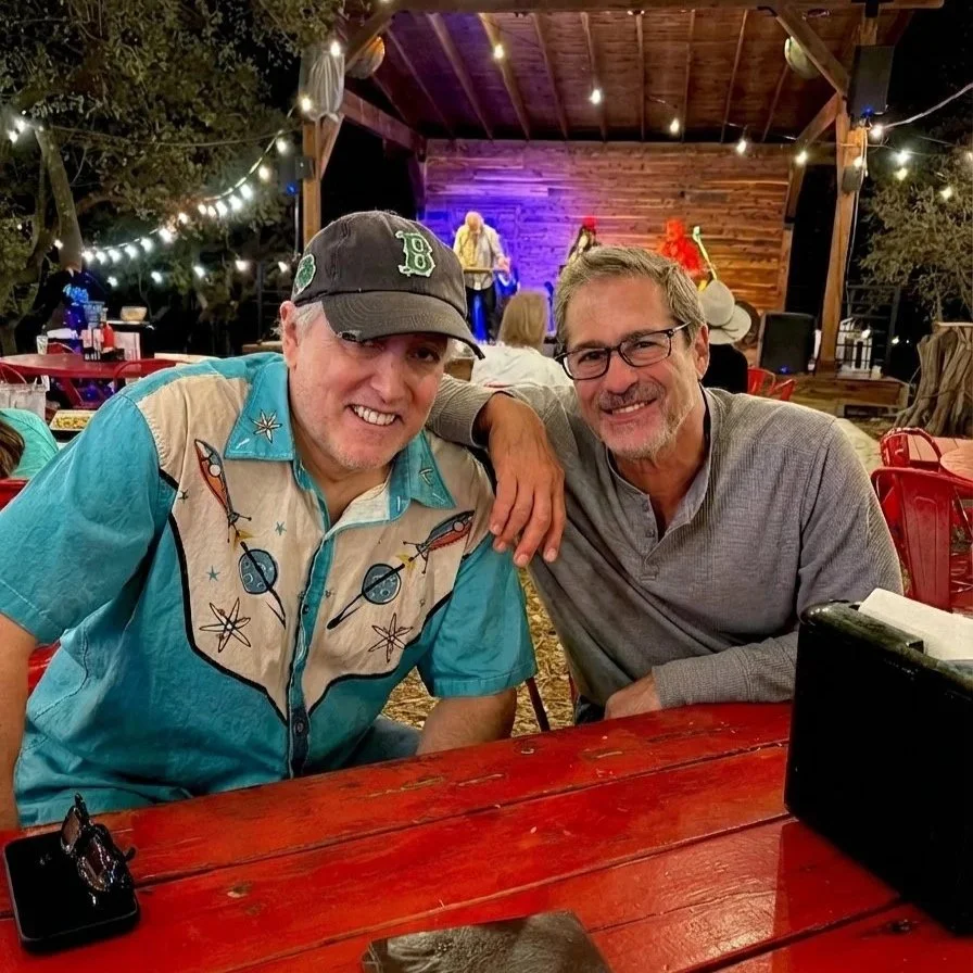 Two adults 50+ socializing at a live music event.