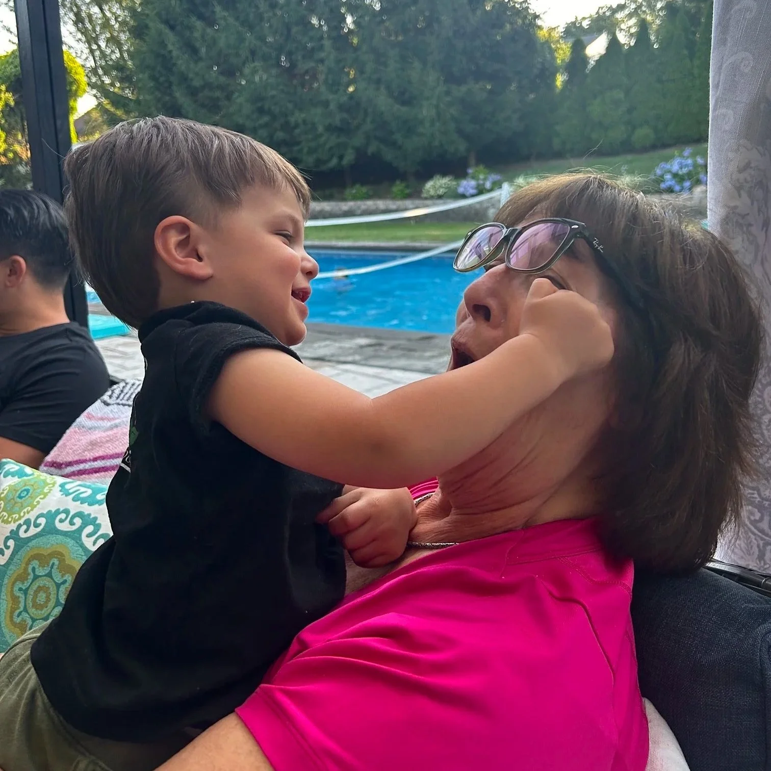 Adult 50+ holding and playing with a young child.