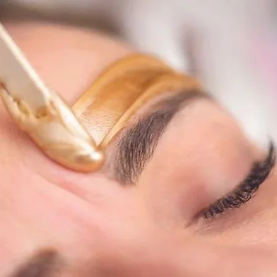 A person receiving a face and eyebrow waxing