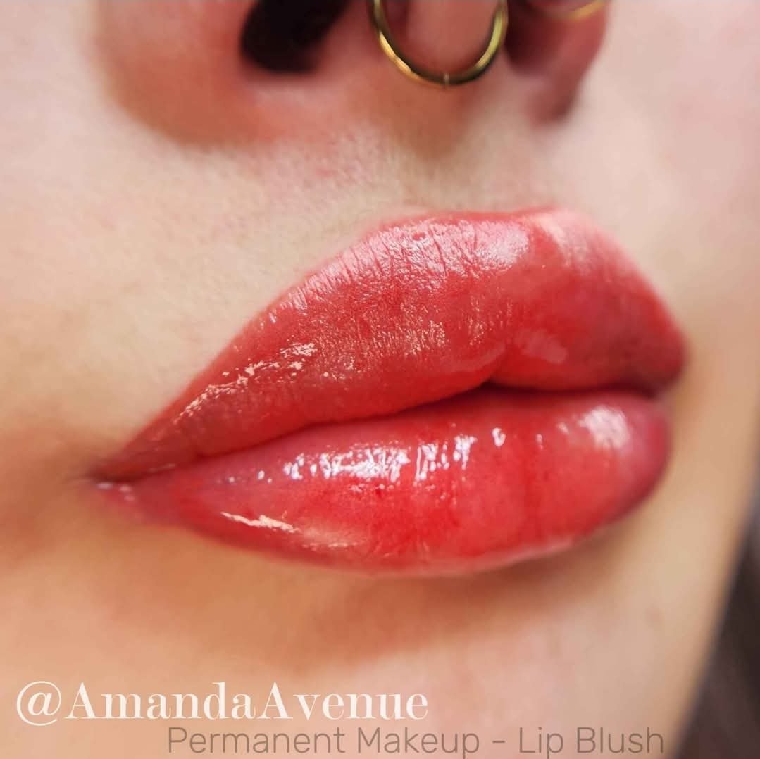 Up close permanent makeup tattoo lip blush color red pink on her lips. Natural looking. Tattoo done by Amanda Avenue