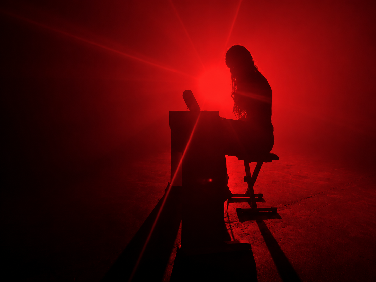 Artist performing live in red stage lighting