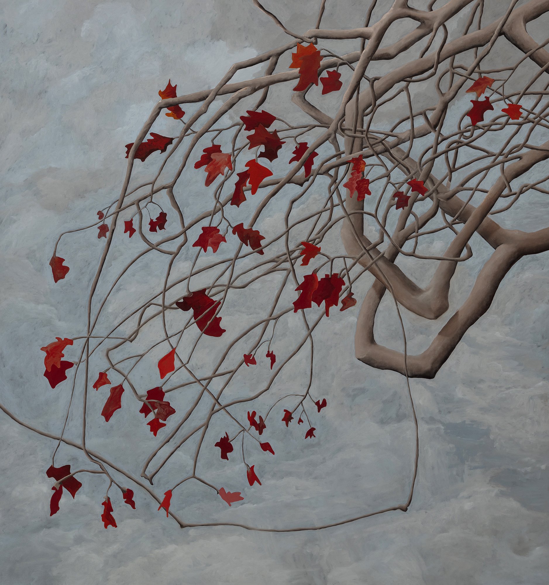 Barren tree branches with red and orange leaf-shaped cutouts hanging against a light gray cloudy sky.